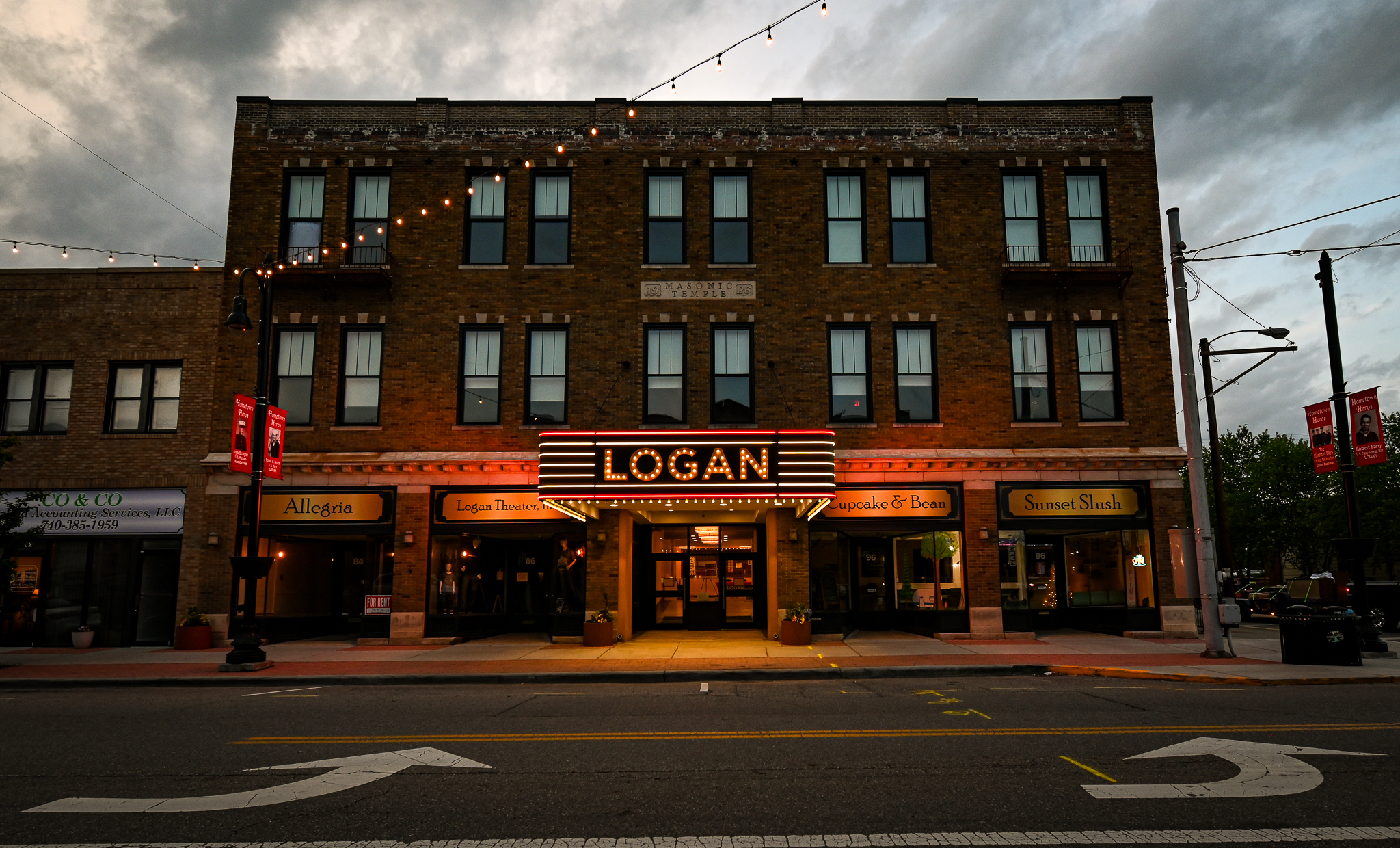 a building with its lights on. The sign says "LOGAN" in large letters