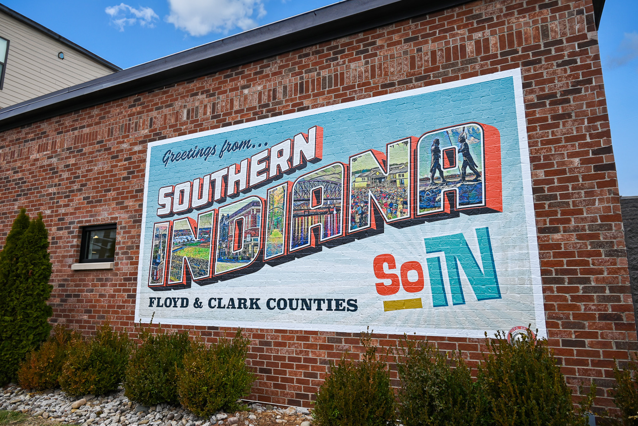 Colorful mural on side of a building that says "Greetings from Southern Indiana"