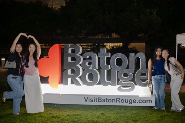 Baton Rouge team poses by a sign that says Baton Rouge